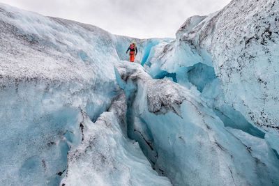 Low angle view of hiker standing on snow formation