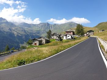 Road amidst buildings against sky