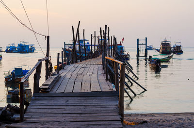 Pier at harbor against clear sky