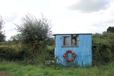 Lifeguard hut on field against sky