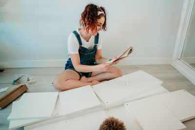 Smiling woman working over wood at home