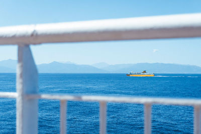 Scenic view of sea seen through railing against sky