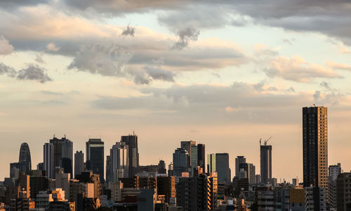 View of cityscape against cloudy sky