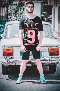 Full length portrait of man standing in car