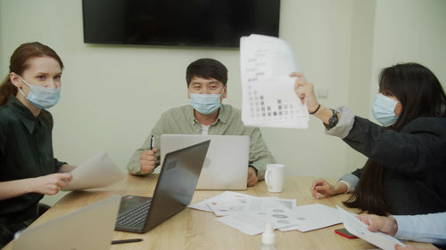 Business people wearing mask holding document