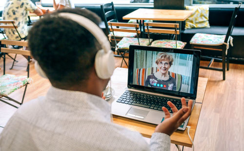 Rear view of man using digital tablet in office