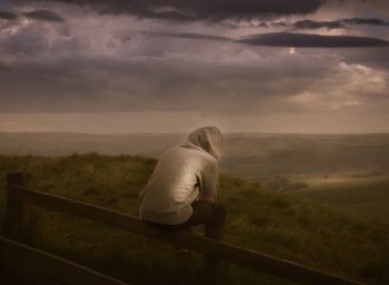 Rear view of man overlooking countryside landscape