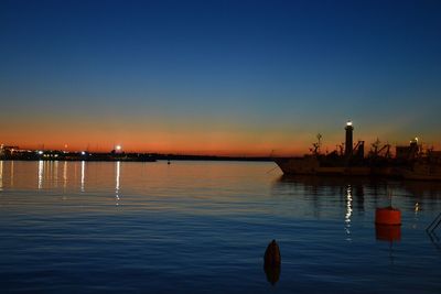Scenic view of lake against clear sky at sunset