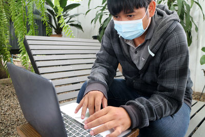 Young woman using laptop while sitting on sofa at home