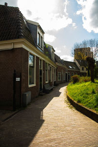 Footpath amidst buildings against sky
