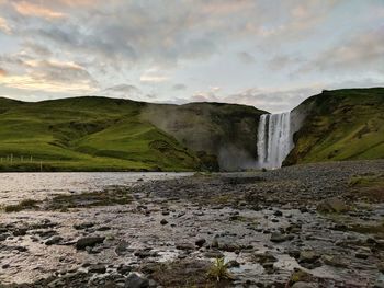 Scenic view of waterfall against sky