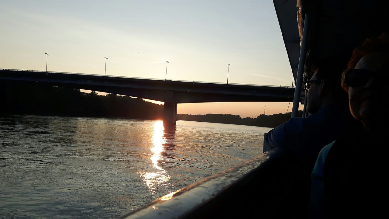 water, sky, real people, transportation, nature, one person, bridge, mode of transportation, connection, bridge - man made structure, leisure activity, men, lifestyles, vehicle interior, sunset, sunlight, built structure, headshot, day, outdoors