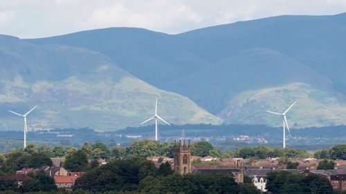 Traditional windmill by mountains against sky