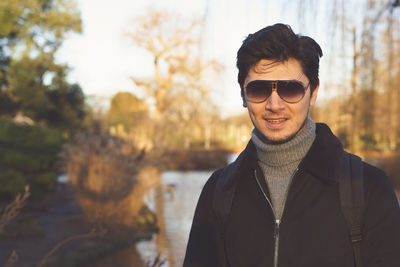 Portrait of young man wearing sunglasses standing outdoors during winter