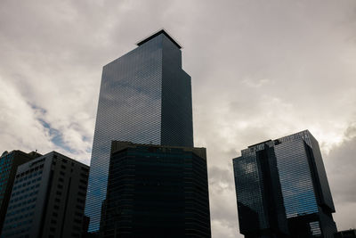 Low angle view of modern building against cloudy sky