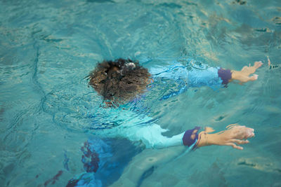High angle view of boy swimming in pool