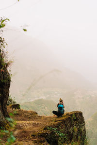 Man sitting on rock in mountains