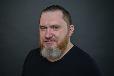 Portrait of young man against black background