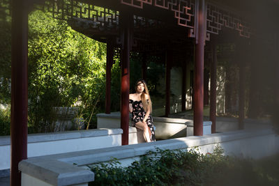 Portrait of woman sitting against trees