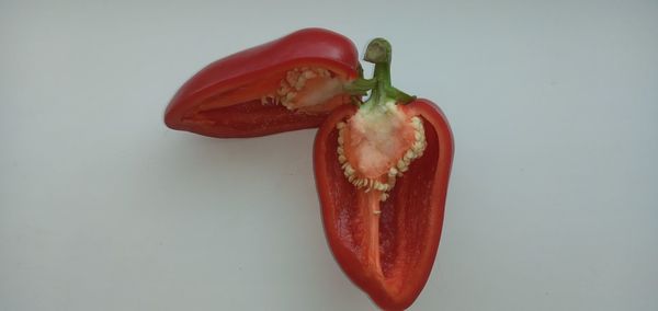 Close-up of red chili peppers against white background