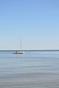 Sailboat in sea against clear sky