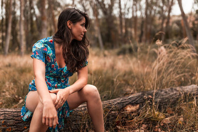 Woman sitting on land in forest