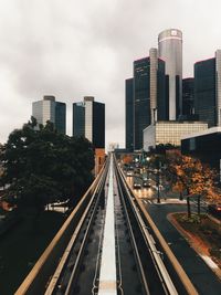 Railroad tracks in city against sky