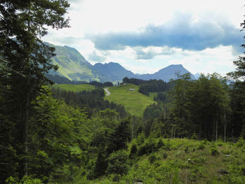 Scenic view of green landscape and mountains against sky