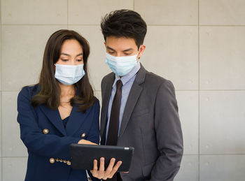 Business people discussing while standing against wall