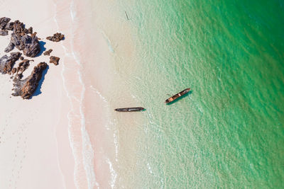 High angle view of empty canoes floating on water at beach