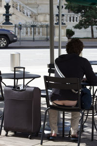 Rear view of man sitting on chair