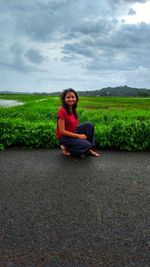Full length of teenage girl sitting on field