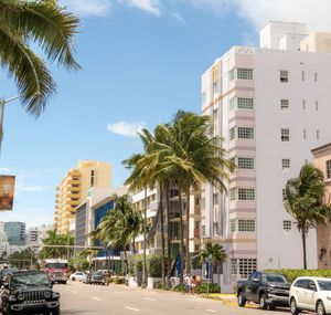 Cars on road by buildings against sky