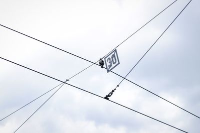 Low angle view of power lines against sky