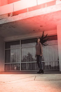 Full length of woman standing by building