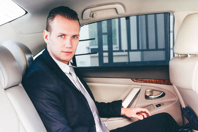 Portrait of young businessman sitting in car