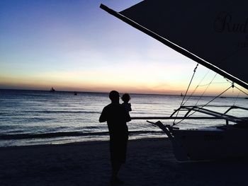 Silhouette of woman in sea at sunset