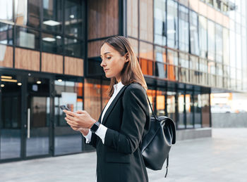 Portrait of young woman standing in city