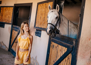 Portrait of young woman standing in stable