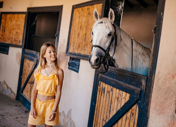 Portrait of young woman standing in stable