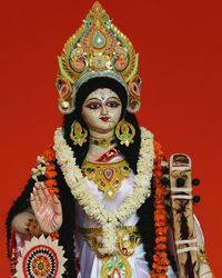 Statue of goddess saraswati against red background