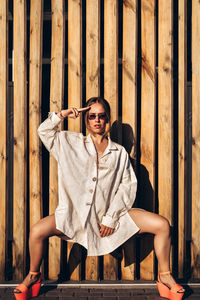 Portrait of young woman against planks