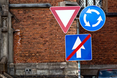 The sign is circular motion, give way and end of a one-way road on the urban background, close-up