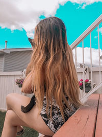 Rear view of woman sitting outdoors