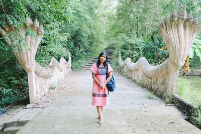 Portrait of woman standing against trees