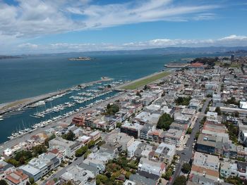 High angle view of townscape by sea against sky