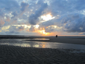 Scenic view of beach against sky during sunset