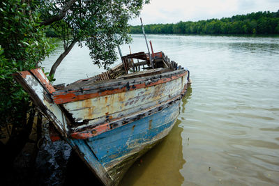 Abandoned boat moored in river