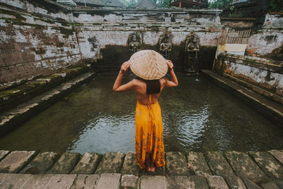 Rear view of woman standing at goa gajah