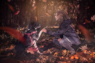 Man feeding horse in forest